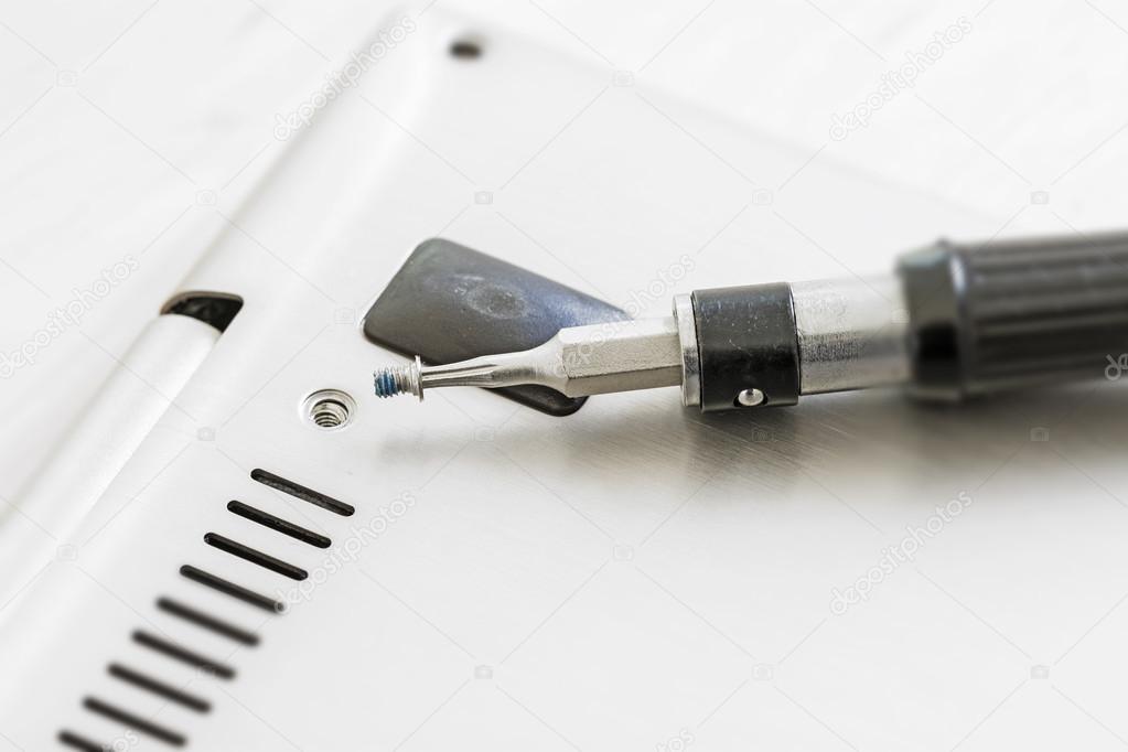 Small screwdriver with screw at a technical device, repair or hardware upgrade