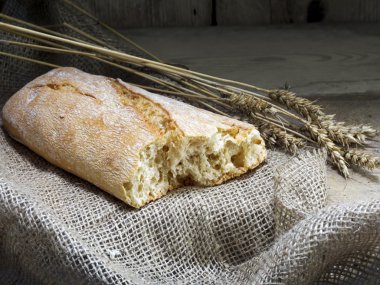 Ciabatta ekmeği ve buğday saplarını rustik ahşap üzerine