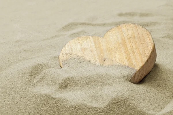 Trä hjärta i sanden på en strand, kärlek koncept — Stockfoto