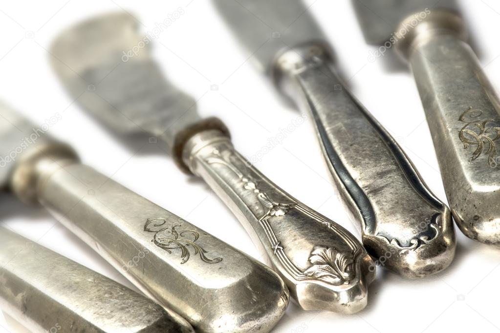 old silver knifes  on white background, selected focus, narrow d