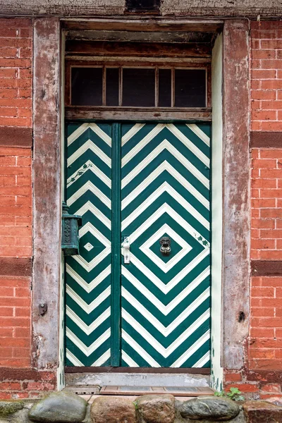 Pintu depan dengan pola hijau dan putih di sebuah rumah tua — Stok Foto