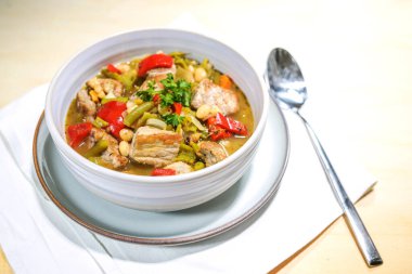 Bir tencere, çorba ya da güveç, domuz eti, dolma biber, fasulye, beyaz ve yeşil seramik kâse, soğuk mevsim için sağlıklı bir yemek pişirme, kopyalama alanı, seçilmiş odak, dar alan