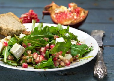 beyaz peynir ve bir rustik ahşap üzerine nar roket salatası