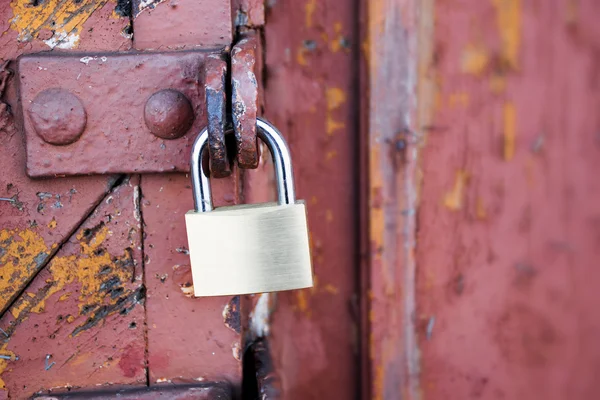 New padlock on an old red wooden gate — Stock Photo, Image