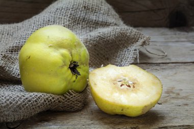 Portugal quince or pear quince (Cydonia oblonga) on rustic wood clipart