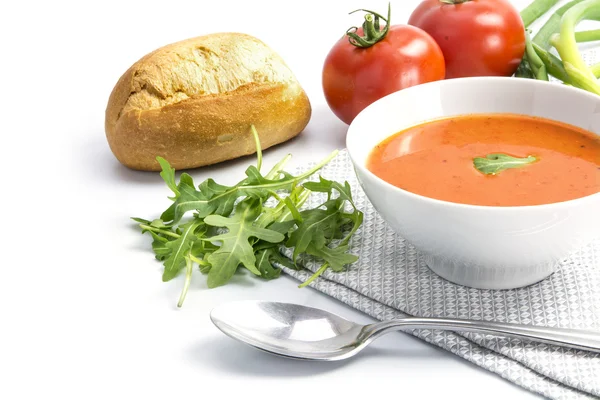 Sopa de tomate en un tazón con panecillos y rúcula sobre una ba blanca — Foto de Stock