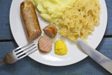 Sosisleri lahana turşusu, patates püresi ve hardal bir pas üzerinde