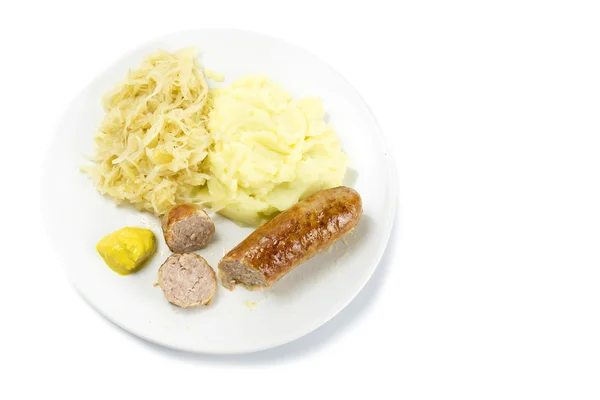 Bratwurst com chucrute, purê de batatas e mustardon um prato — Fotografia de Stock