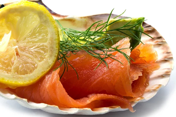 Smoked salmon with avocado, lemon and dill in a scallop shell — Stock Photo, Image