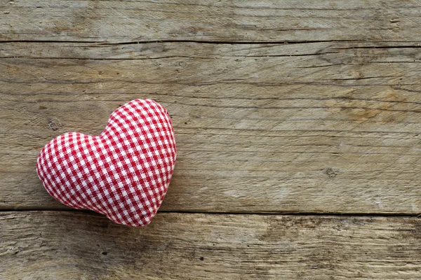 Corazón de tela con patrón rojo blanco en madera vieja rústica — Foto de Stock