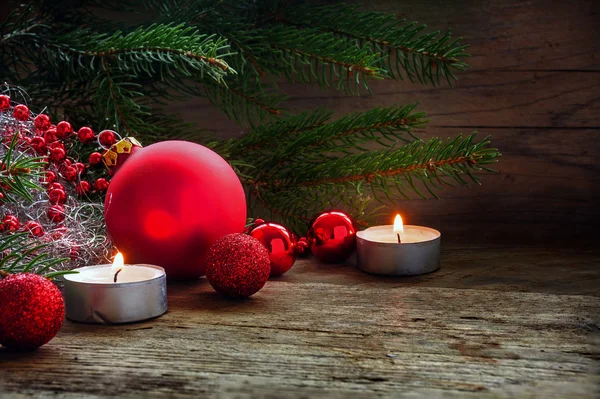 Weihnachtsdekoration mit roten Kugeln und Kerzen auf warmem Rustikalem — Stockfoto