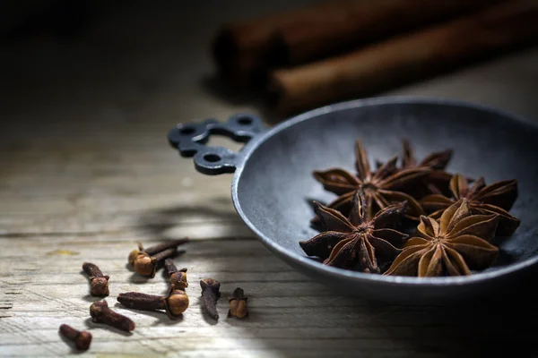 Spezie da forno, anice stellato, cannella e chiodi di garofano su un bosco rustico — Foto Stock