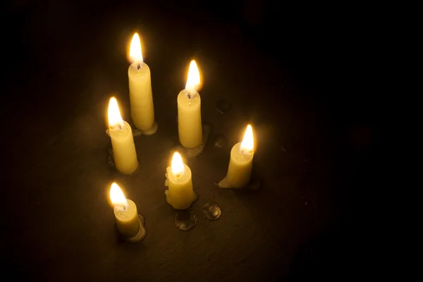 Six burning candles on black, view from above, copy space — Stock Photo, Image