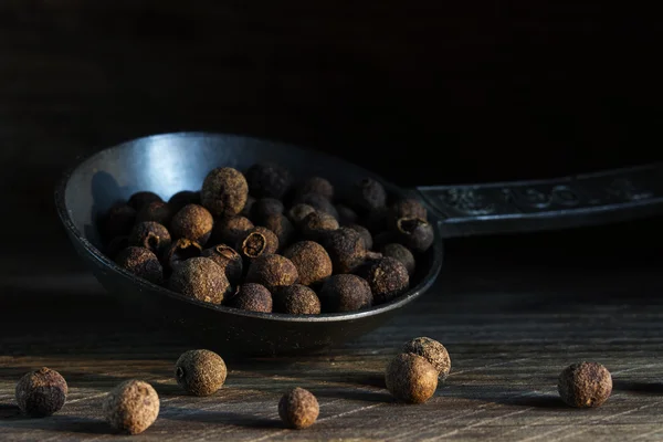 Piment auf einem alten Metalllöffel auf dunklem rustikalem Holzhintergrund — Stockfoto