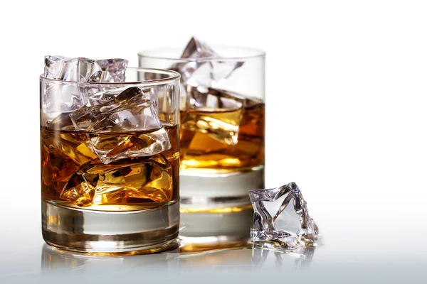 Twee glazen van scotch whisky met ijsblokjes, achtergrond verdwijnt t — Stockfoto