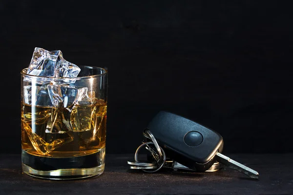 Ουίσκι γυαλί και αυτοκίνητο πλήκτρα στο σκοτεινό ρουστίκ ξύλινα, έννοια αλκοόλ — Φωτογραφία Αρχείου