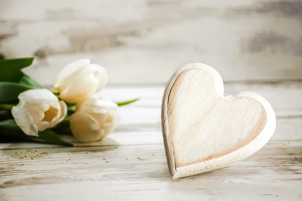 Corazón de madera y tulipanes sobre un fondo de madera pintado blanco, r —  Fotos de Stock