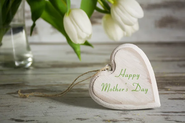 Wooden heart shape in front of white tulips for mothers day — Stock Photo, Image