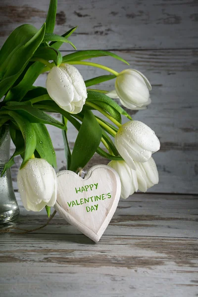 Kytice s bílými tulipány a valentinky srdce ze dřeva — Stock fotografie