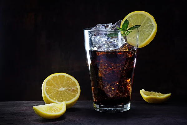 Bicchiere di cola o tè freddo con fette di limone e menta piperita garnis — Foto Stock