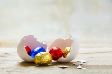 renkli sarılmış çikolata yumurta beyaz tavuk yumurta kabuğu üzerinde bir