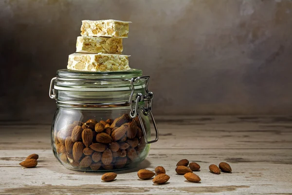 Torrone festivo o turrón en un frasco de vidrio con almendras en un rusti — Foto de Stock