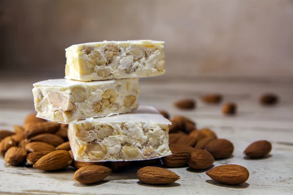 Torrone or nougat and almonds on a rustic wooden table, close up — Stock Photo, Image