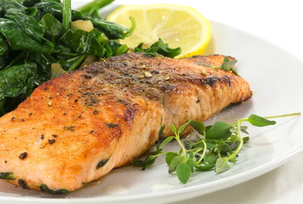 Grilled salmon with thyme, lemon and spinach on white, vegetaria — Stockfoto