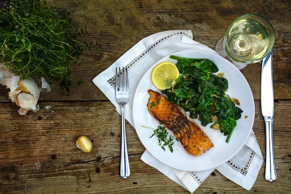 Grilled salmon with thyme, lemon, spinach and white wine on a da — Stock fotografie