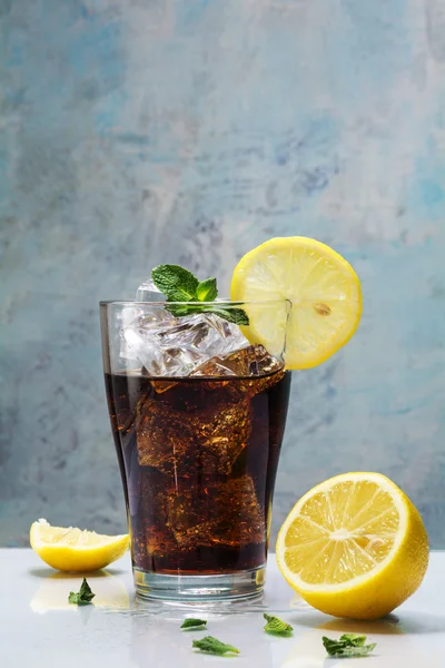 Vidro de cola ou coque com cubos de gelo, fatias de limão e peppermina — Fotografia de Stock