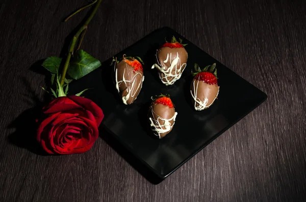 strawberrys inundateds siyah bir tabak içinde çikolata ile 