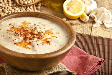 Köy zemininde ahşap masa ile Türk geleneksel işkembe çorbası