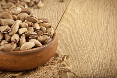 Arka planda bir ahşap plaka ve kavram Antep fıstığı. Seçici odak