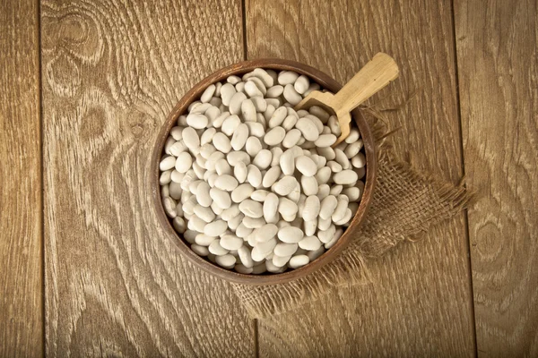 Haricots blancs dans un bol en bois avec fond concept turc traditionnel — Photo