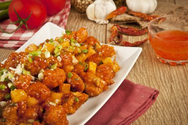 Tatlı ve ekşi tavuk taze soğan ve kavram tahta arka plan ile