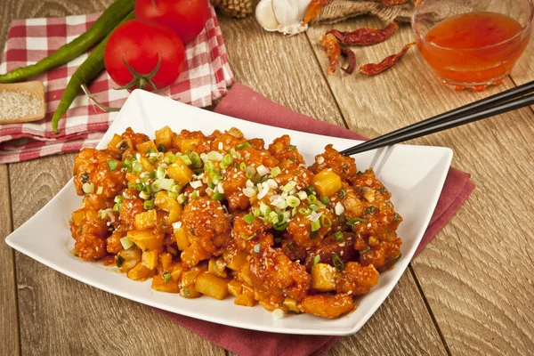 Süß-saures Hühnchen mit frischer Zwiebel und Konzeptholzhintergrund — Stockfoto