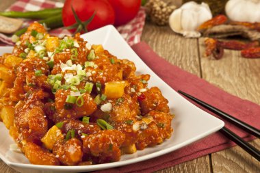 Tatlı ve ekşi tavuk taze soğan ve kavram tahta arka plan ile