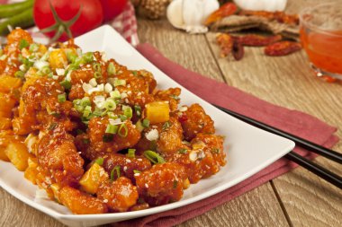 Tatlı ve ekşi tavuk taze soğan ve kavram tahta arka plan ile