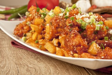 Tatlı ve ekşi tavuk taze soğan ve kavram tahta arka plan ile