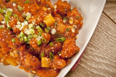 Tatlı ve ekşi tavuk taze soğan ve kavram tahta arka plan ile