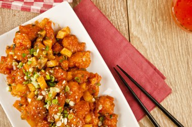 Tatlı ve ekşi tavuk taze soğan ve kavram tahta arka plan ile