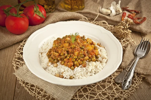 Pilaf de riz turc traditionnel avec viande et légumes pois dans une assiette blanche sur fond de concept en bois — Photo