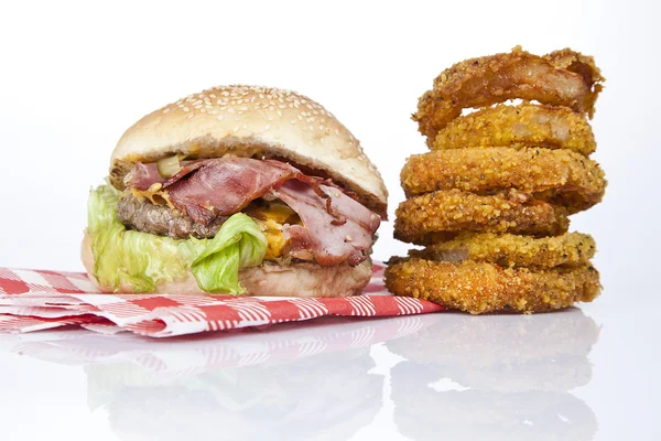 Hambúrguer gourmet com cogumelos de queijo e bacon de redução grosso e um lado de um pickle e algumas batatas fritas parmesão, batatas fritas de cebola . — Fotografia de Stock