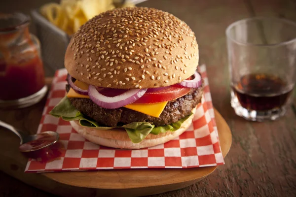 Cheeseburger deluxe clássico com alface, cebola, tomate e picles em um pão de sementes de gergelim — Fotografia de Stock