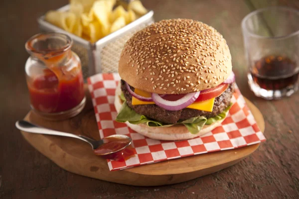 Hamburguesa clásica de lujo con lechuga, cebolla, tomate y encurtidos en un bollo de semillas de sésamo — Foto de Stock