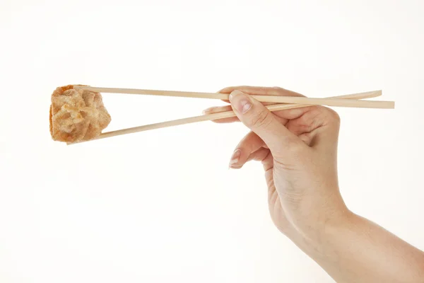 Mão segurando chinês Wonton bolinho com pauzinhos, isolado em branco — Fotografia de Stock