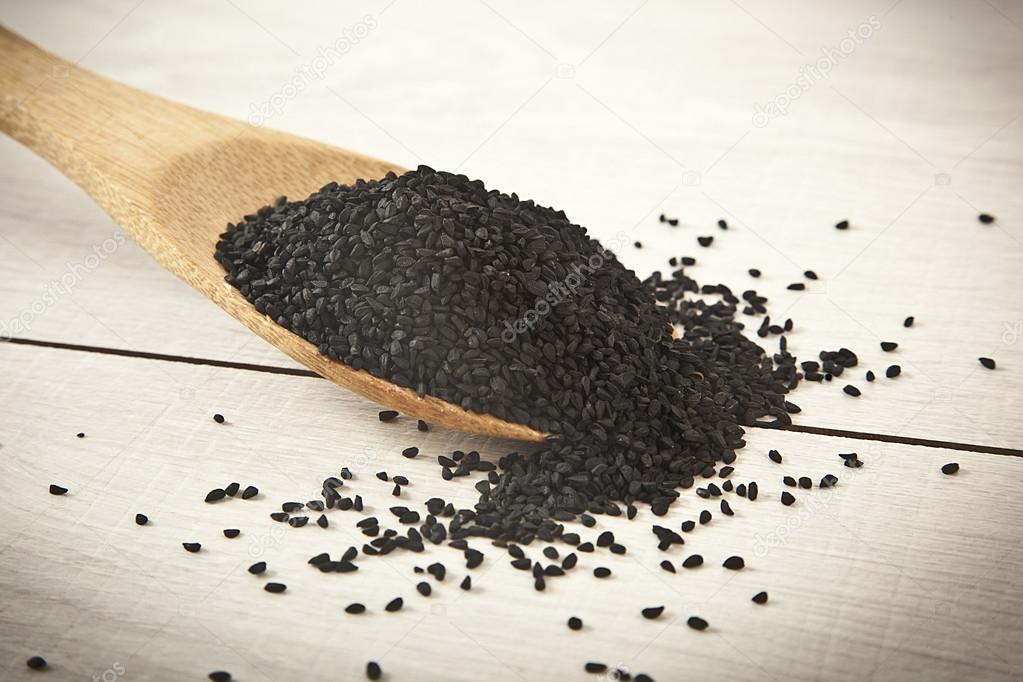 (Black cumin) on wooden spoon. Macro shot