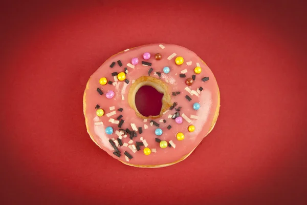 Donut with Pink and Yellow on Red Background — Stock Photo, Image