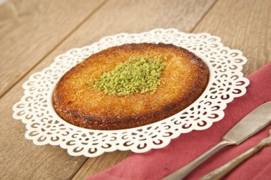 Delicious traditional Turkish kunefe with pistachio on it. Served hot and with syrup clipart