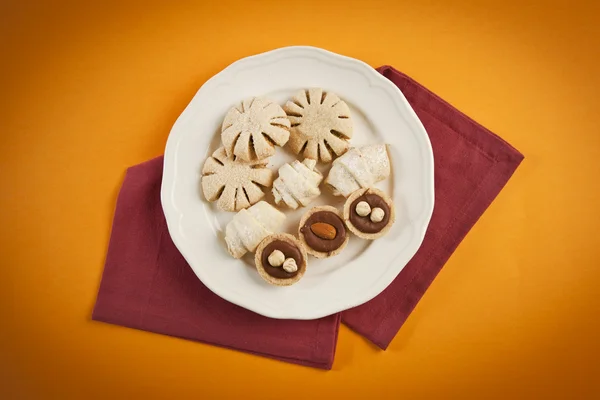 Biscoitos e biscoitos mistos em uma placa branca — Fotografia de Stock